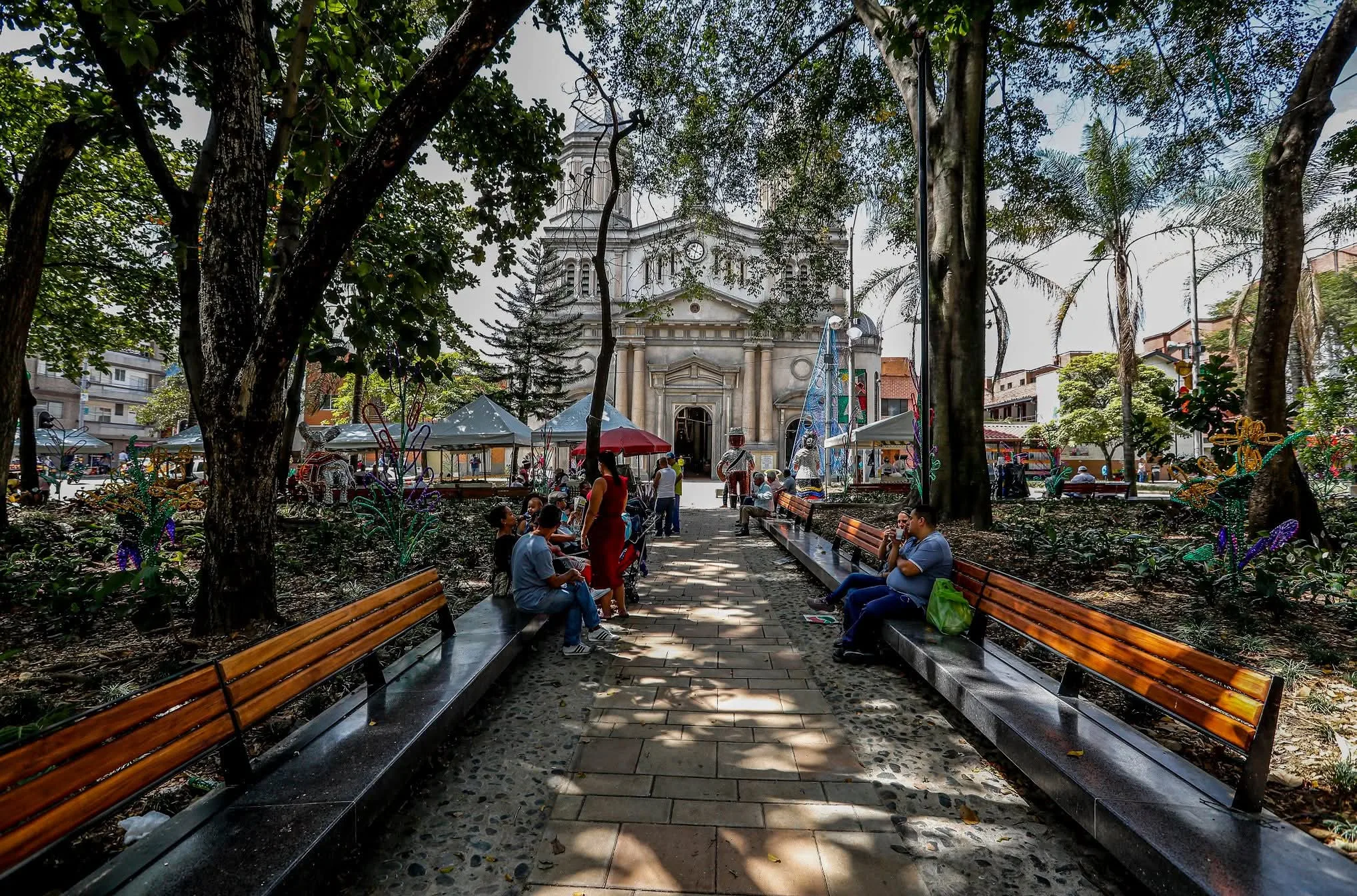 parque tradicional de un barrio residencial de Medellín con árboles y bancas