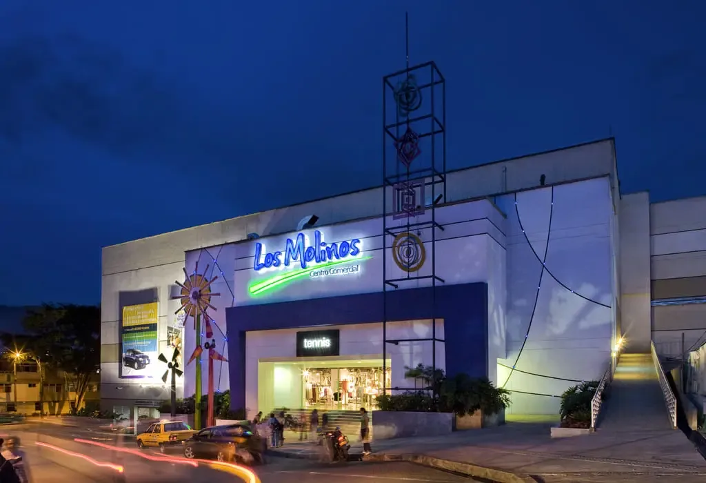 fachada de un centro comercial de barrio con parqueadero y accesos peatonales